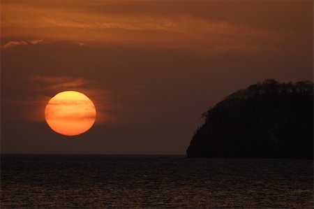 Beautiful sunset over Costa Rica. Red sky. Full disk sun. Photographie de stock - Aubaine LD & Abonnement, Code: 400-05211158