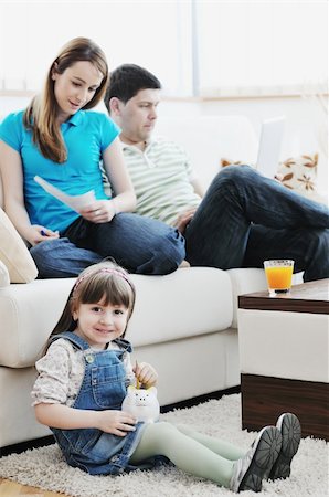 young happy family at bright and modern living room puting money in piggy bank and working on laptop computer on home finance Stock Photo - Budget Royalty-Free & Subscription, Code: 400-05211270