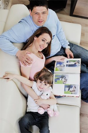 family photos in album - happy young family looking old pictures in photo album at home Stock Photo - Budget Royalty-Free & Subscription, Code: 400-05211294