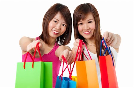 simsearch:400-06092781,k - Happy Asian girls showing their shopping bags against white background. Photographie de stock - Aubaine LD & Abonnement, Code: 400-05211715