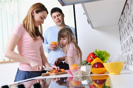 happy young family have lunch time with fresh fruits and vegetable food in bright kitchen Stock Photo - Budget Royalty-Free & Subscription, Code: 400-05211862