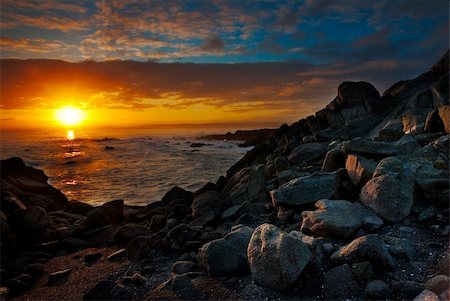 The sun illuminates a rocky Monterey beach showing the beautiful light in the blue sky Foto de stock - Super Valor sin royalties y Suscripción, Código: 400-05224573