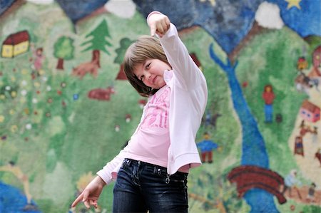 happy young girl posing and jumping with abstract urban style painting bacground begind Stock Photo - Budget Royalty-Free & Subscription, Code: 400-05227174