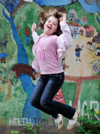 happy young girl posing and jumping with abstract urban style painting bacground begind Stock Photo - Budget Royalty-Free & Subscription, Code: 400-05227198