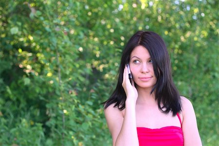 Young woman is talking on the phone in the garden Stockbilder - Microstock & Abonnement, Bildnummer: 400-05220891