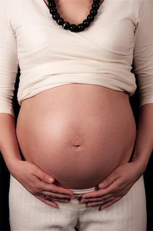 simsearch:400-05084530,k - Pregnant mother holding belly exposing the bump Foto de stock - Super Valor sin royalties y Suscripción, Código: 400-05221924