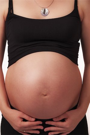 simsearch:400-04334843,k - Pregnant mother holding belly exposing the bump Foto de stock - Royalty-Free Super Valor e Assinatura, Número: 400-05221921
