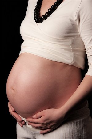 simsearch:400-05084530,k - Pregnant mother holding belly exposing the bump Foto de stock - Super Valor sin royalties y Suscripción, Código: 400-05221923