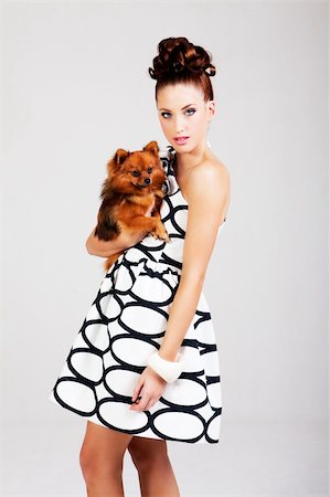 simsearch:693-03707560,k - Portrait of a young woman holding a small dog. She is dressed in a black and white dress. Vertical shot. Fotografie stock - Microstock e Abbonamento, Codice: 400-05222829