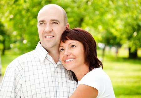 simsearch:400-05234340,k - adult couple of husband and wife in park, both smiling and looking away from camera Stock Photo - Budget Royalty-Free & Subscription, Code: 400-05234340