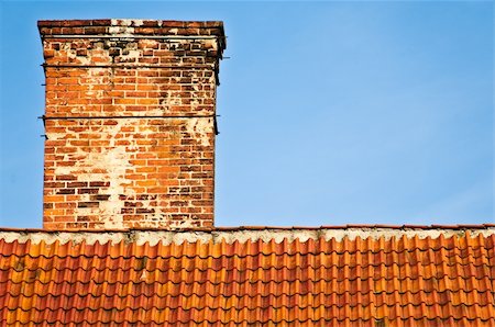 red and orange roof top of old house with brick chimney and blue sky in background Fotografie stock - Microstock e Abbonamento, Codice: 400-05234743