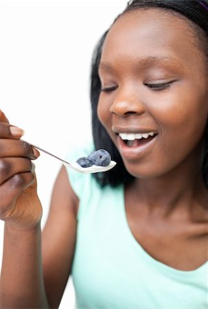 simsearch:400-04043868,k - Afro-american woman eating a yogurt with blueberries against a white background Stock Photo - Budget Royalty-Free & Subscription, Code: 400-05235240