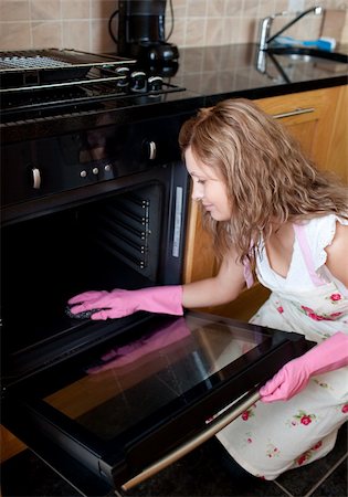 simsearch:400-04139196,k - Young woman cleaning the oven in the kitchen Foto de stock - Royalty-Free Super Valor e Assinatura, Número: 400-05236484