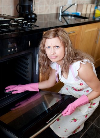 Annoyed woman cleaning the oven in the kitchen Stock Photo - Budget Royalty-Free & Subscription, Code: 400-05236482