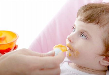 mother feeding baby yellow spoon white background Stock Photo - Budget Royalty-Free & Subscription, Code: 400-05239965