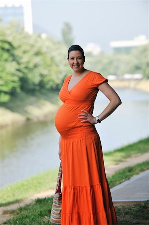 simsearch:400-05230274,k - beautiful young happy pregnant woman outdoor in bright nature in orange dress Foto de stock - Royalty-Free Super Valor e Assinatura, Número: 400-05230269