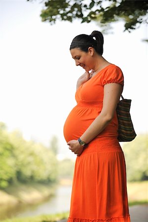 simsearch:400-05230274,k - beautiful young happy pregnant woman outdoor in bright nature in orange dress Foto de stock - Royalty-Free Super Valor e Assinatura, Número: 400-05230273