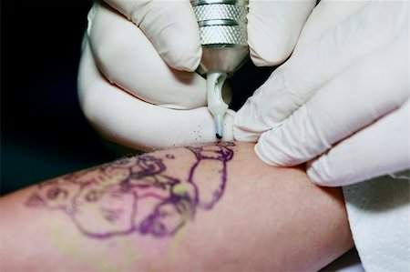 simsearch:400-03921000,k - A tattoo artist applying his craft onto the hand of a female Stockbilder - Microstock & Abonnement, Bildnummer: 400-05230654