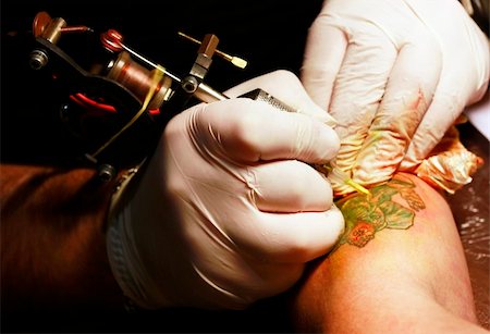 A tattoo artist applying his craft onto the hand of a female Stock Photo - Budget Royalty-Free & Subscription, Code: 400-05230658