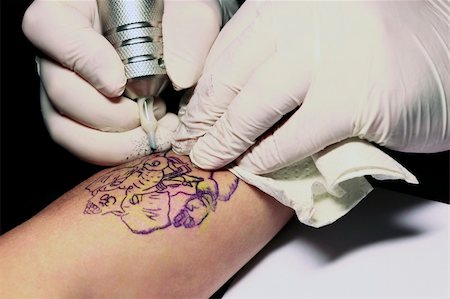 simsearch:400-03921000,k - A tattoo artist applying his craft onto the hand of a female Stockbilder - Microstock & Abonnement, Bildnummer: 400-05230944