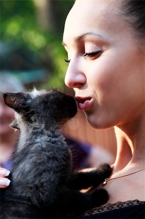 The young beautiful dark-haired woman holds in hands of a black kitten. Stock Photo - Budget Royalty-Free & Subscription, Code: 400-05231418