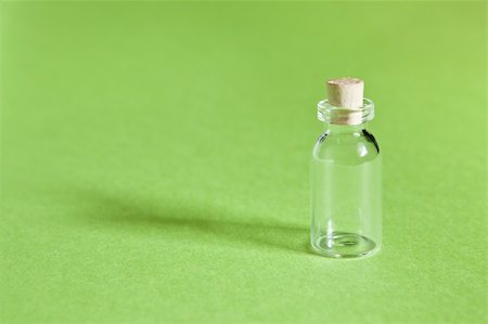 Tiny glass bottle with cork stopper on green background. Stock Photo - Budget Royalty-Free & Subscription, Code: 400-05231657
