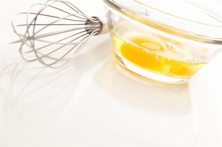 simsearch:400-05231767,k - Hand Mixer with Eggs in a Glass Bowl on a Reflective White Background. Photographie de stock - Aubaine LD & Abonnement, Code: 400-05231764