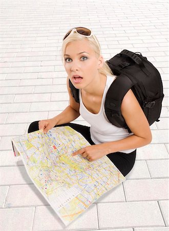 pretty girl in vacation with backpack sitting down with map and looking in camera surprised Stock Photo - Budget Royalty-Free & Subscription, Code: 400-05232294