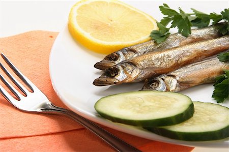 pickled lemon - Smoked fishes with lemon, cucumber and green parsley on white plate. Close-up. Studio photography. Stock Photo - Budget Royalty-Free & Subscription, Code: 400-05232344