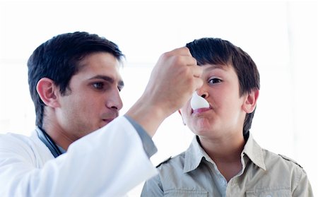 Male doctor giving medicine to a little boy against a white background Stockbilder - Microstock & Abonnement, Bildnummer: 400-05232825