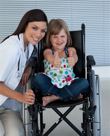 Portrait of a little girl on a wheelchair with her doctor smiling at the camera Stockbilder - Microstock & Abonnement, Bildnummer: 400-05232837