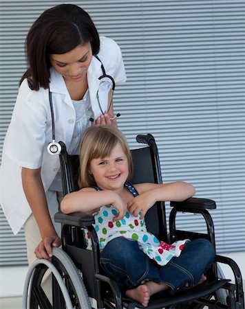 Female doctor pushing a wheelchair in the hospital Stockbilder - Microstock & Abonnement, Bildnummer: 400-05232838