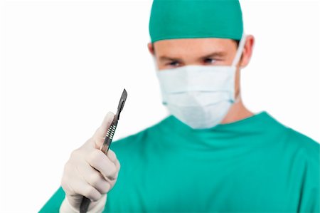 simsearch:400-05192324,k - Self-assured surgeon holding a scalpel isolated on a white background Stock Photo - Budget Royalty-Free & Subscription, Code: 400-05232855