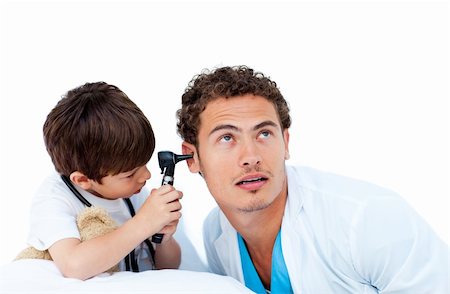 simsearch:400-05265698,k - Cute little boy checking doctor's ears against a white background Foto de stock - Super Valor sin royalties y Suscripción, Código: 400-05232857