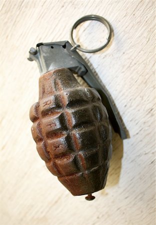 old prop grenade with pin on a white wood surface Fotografie stock - Microstock e Abbonamento, Codice: 400-05233206