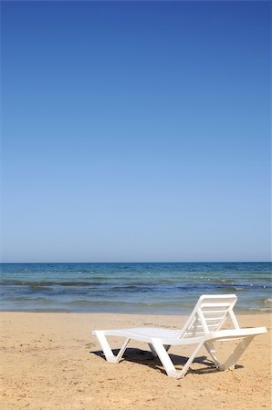 one deckchairs on the beach under blue sky Stock Photo - Budget Royalty-Free & Subscription, Code: 400-05233294