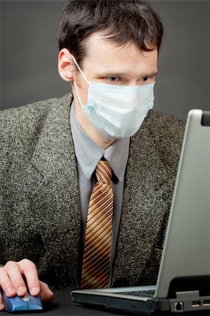 simsearch:400-05265698,k - A man in a medical mask works with the laptop Foto de stock - Super Valor sin royalties y Suscripción, Código: 400-05244007