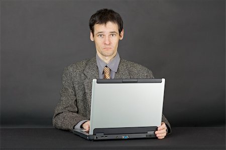 simsearch:400-05265698,k - A young man working with laptop computer on a dark background Foto de stock - Super Valor sin royalties y Suscripción, Código: 400-05244250