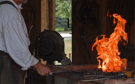 Blacksmith works on a heart trivet at the kiln Stockbilder - Microstock & Abonnement, Bildnummer: 400-05246730