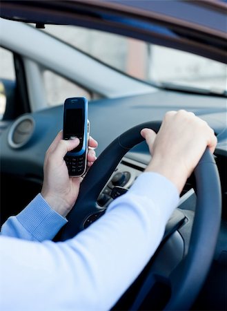 simsearch:400-04843851,k - Close-up of a cute young man sending a message with his mobile phone sitting in his car Stockbilder - Microstock & Abonnement, Bildnummer: 400-05247015