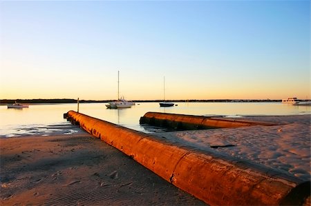 simsearch:400-05255037,k - Still and serene sunrise over beach with water overflows and boats. Stock Photo - Budget Royalty-Free & Subscription, Code: 400-05247055