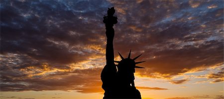 The silhouette of Statue of Liberty under sunrise background Stock Photo - Budget Royalty-Free & Subscription, Code: 400-05247305