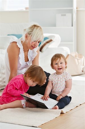 simsearch:400-04712944,k - Laughing little girl using a laptop with her family at home Stock Photo - Budget Royalty-Free & Subscription, Code: 400-05249131
