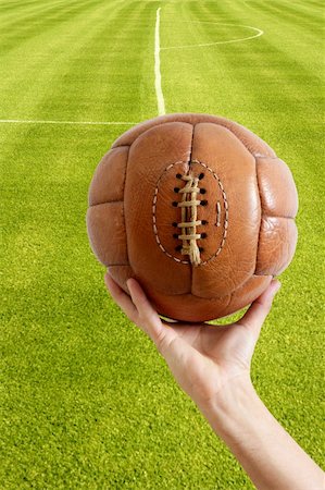 simsearch:400-06083555,k - Aged vintage retro football leather ball in man hand grass field Stockbilder - Microstock & Abonnement, Bildnummer: 400-05240028