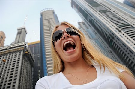 Happy young woman with sunglasses at big city background Stockbilder - Microstock & Abonnement, Bildnummer: 400-05240804
