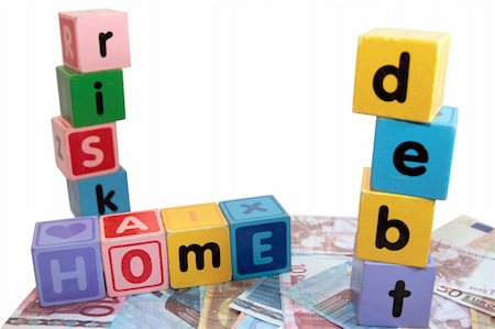 simsearch:400-05241318,k - assorted childrens toy letter building blocks against a white background on money that spell home debt risk Stock Photo - Budget Royalty-Free & Subscription, Code: 400-05241318
