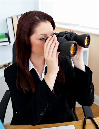 simsearch:400-04648812,k - Concentrated businesswoman looking through spyglasses sitting in her office Stock Photo - Budget Royalty-Free & Subscription, Code: 400-05242658