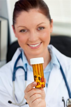 simsearch:400-09028278,k - Delighted female doctor holding pills into the camera in her office Fotografie stock - Microstock e Abbonamento, Codice: 400-05242661