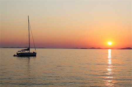 Romantic sunset with silhouette of yacht Stock Photo - Budget Royalty-Free & Subscription, Code: 400-05242884