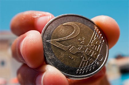 simsearch:700-00047827,k - FishEye closeup of a used 2 euro coin, held with a four finger grip. Stockbilder - Microstock & Abonnement, Bildnummer: 400-05242955